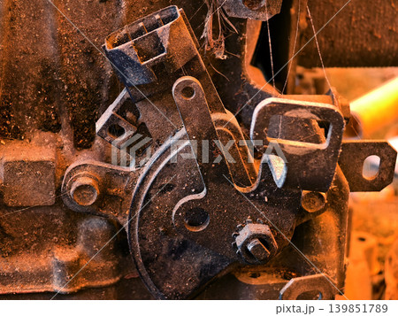 Rusted engine parts and corroded gears scattered across the sandy ground Rusted engine parts and corroded gears scattered across the sandy ground 139851789