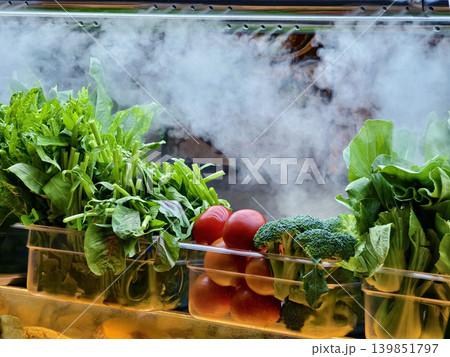 foggy refrigeration creating display with leafy greens and eggplants in glass case foggy refrigeration creating display with leafy greens and eggplants in glass case 139851797