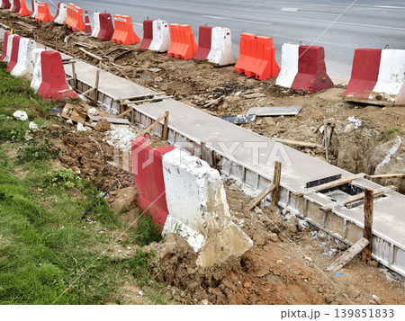 Narrow ditch with reinforcement, waterproof concrete trench bounded by soil and support stakes 139851833