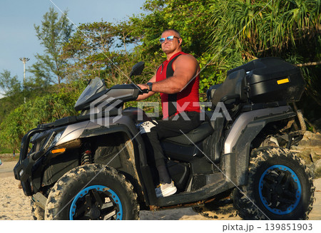 A man engages in extreme ATV riding on sand beach early in the morning A man engages in extreme ATV riding on sand beach early in the morning 139851903