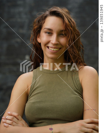 Empowered woman poses against wall with stylish attire 139851945