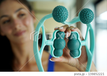 Woman blue sportswear adjusting teal massage roller device 139852221