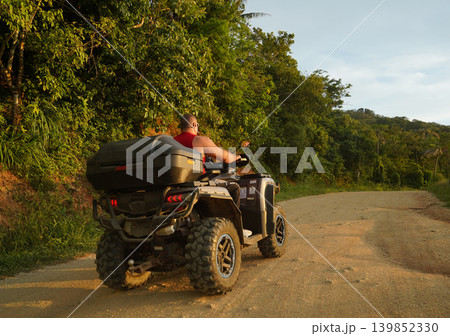 A man engages in extreme ATV riding on mountains in the evening A man engages in extreme ATV riding on mountains in the evening 139852330