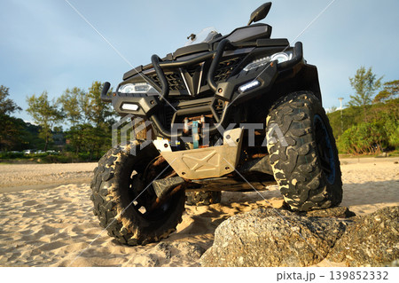 A man engages in extreme ATV riding on sand beach early in the morning 139852332