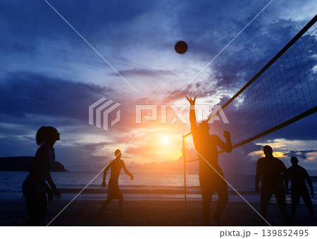 Young people playing beach volleyball by the ocean at sunset Young people playing beach volleyball by the ocean at sunset 139852495