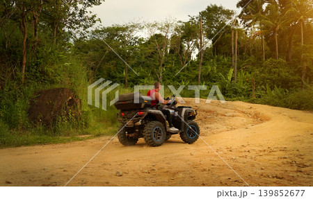 A man engages in extreme ATV riding on mountains in the evening A man engages in extreme ATV riding on mountains in the evening 139852677