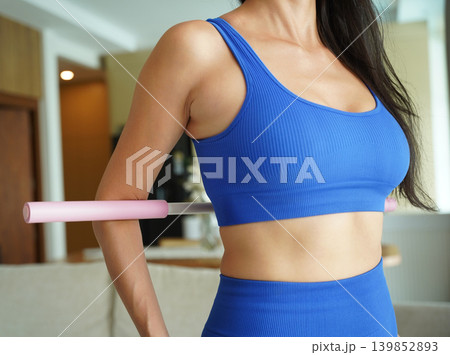 Woman blue sportswear using physiotherapy device to correct his posture Woman blue sportswear using physiotherapy device to correct his posture 139852893