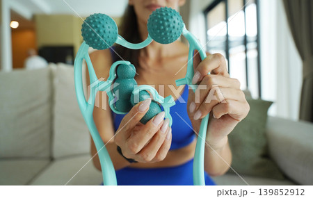 Woman blue sportswear adjusting teal massage roller device 139852912