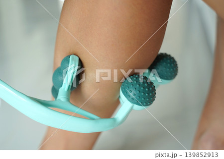Calf recovery using handheld teal massage roller device 139852913