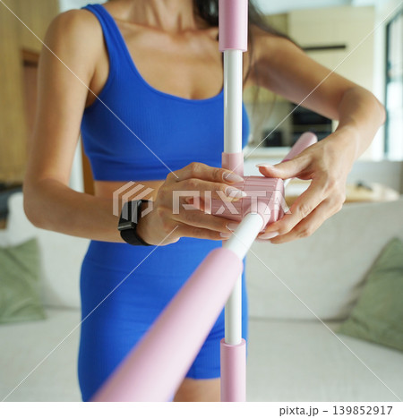 Woman blue sportswear adjusting physiotherapy device to correct his posture 139852917