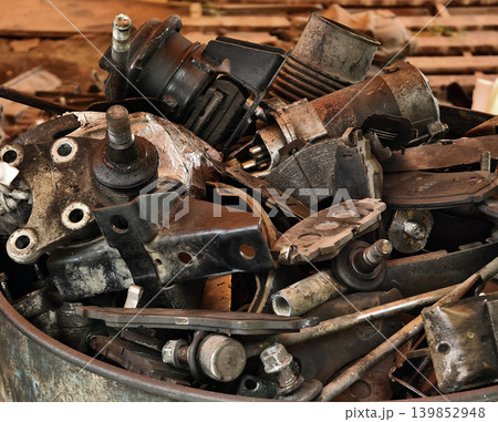 Pile of rusted motor components and gears in cluttered scrap heap 139852948