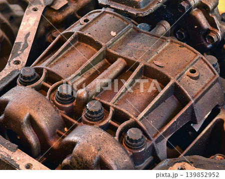 Rusted engine parts and corroded gears scattered across the sandy ground Rusted engine parts and corroded gears scattered across the sandy ground 139852952