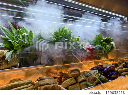 foggy refrigeration creating display with leafy greens and eggplants in glass case foggy refrigeration creating display with leafy greens and eggplants in glass case 139852968