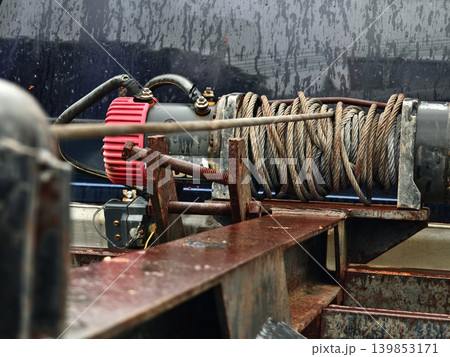 Rust covered winch with coiled rope under tension on the truck 139853171