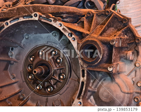 Rusted engine parts and corroded gears scattered across the sandy ground Rusted engine parts and corroded gears scattered across the sandy ground 139853179