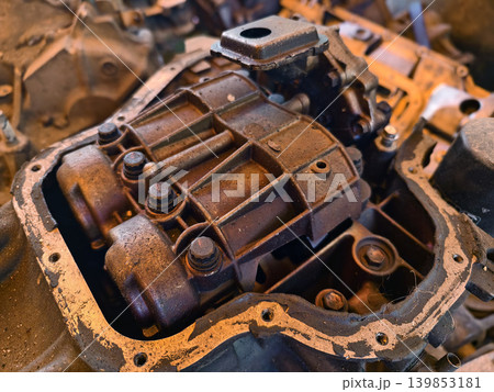 Rusted engine parts and corroded gears scattered across the sandy ground Rusted engine parts and corroded gears scattered across the sandy ground 139853181