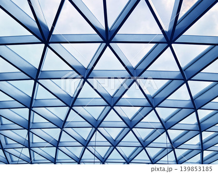 Glass canopy showcasing repeating geometric frames and day light 139853185