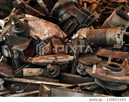 Pile of rusted motor components and gears in cluttered scrap heap 139853193