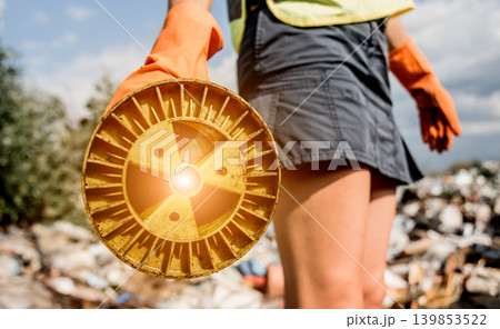 Woman volunteer helps clean the field of nuclear waste and plastic garbage. Woman volunteer helps clean the field of nuclear waste and plastic garbage. 139853522