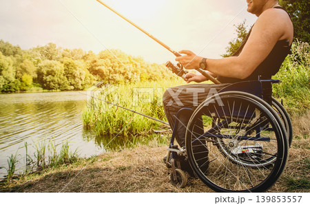 Handicapped man fishing at a lake. Wheelchair camping. 139853557