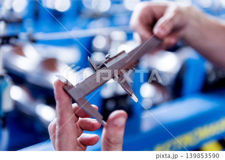 Male hands hold vernier caliper and measure steel collar. Male hands hold vernier caliper and measure steel collar. 139853590
