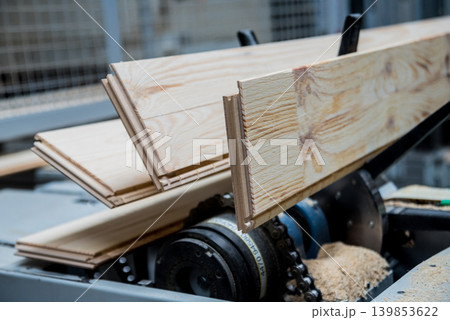 Production line of the wooden floor factory. CNC automatic woodworking machine. Production line of the wooden floor factory. CNC automatic woodworking machine. 139853622