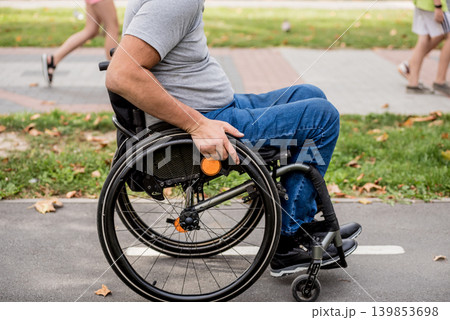 Handicapped man in wheelchair walk at the park alley Handicapped man in wheelchair walk at the park alley 139853698