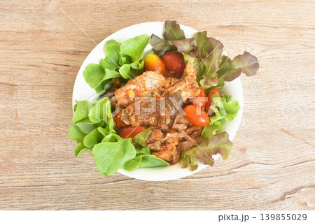 spicy fried roasted duck meat with tomato in curry and red oak salad on bowl spicy fried roasted duck meat with tomato in curry and red oak salad on bowl 139855029