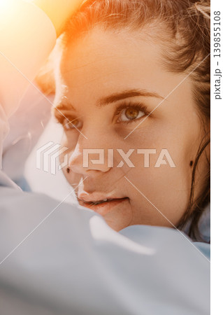 Woman portrait sunlight illuminates the face of a young brunette looking up into the golden hour rays Woman portrait sunlight illuminates the face of a young brunette looking up into the golden hour rays 139855108