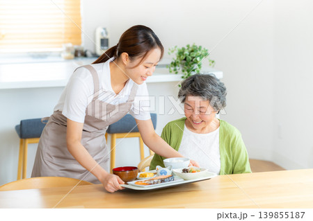 食事の準備をするヘルパーとシニア女性 139855187