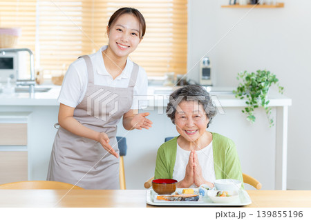 食事の準備をするヘルパーとシニア女性 139855196