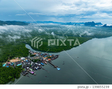 Aerial view top view of the fisherman village with fishing boats and house roof at the pier in Phang Nga Thailand Aerial view top view of the fisherman village with fishing boats and house roof at the pier in Phang Nga Thailand 139855239
