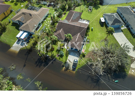 Consequences of natural disaster. Heavy flood with high water surrounding residential houses after hurricane Ian rainfall in Florida residential area Consequences of natural disaster. Heavy flood with high water surrounding residential houses after hurricane Ian rainfall in Florida residential area 139856726