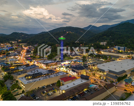 Aerial landscape of evening at Gatlinburg city center with busy tourist streets, main Parkway filled with shops and restaurants, and scenic Smoky Mountains in the background. Aerial landscape of evening at Gatlinburg city center with busy tourist streets, main Parkway filled with shops and restaurants, and scenic Smoky Mountains in the background. 139856762