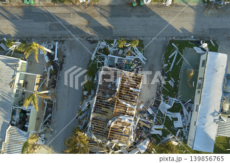 Hurricane destroyed suburban houses roofs in Florida mobile home residential area. Consequences of natural disaster 139856765