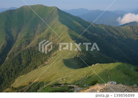 朝の光に照らされた稜線の登山道と緑の山肌が広がる爽やかな山の風景 朝の光に照らされた稜線の登山道と緑の山肌が広がる爽やかな山の風景 139856899