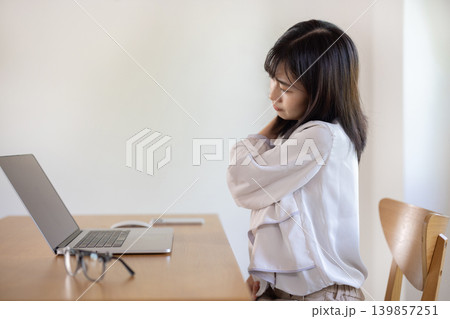 パソコン作業中に肩に手を当てて眉をしかめる日本人の若い女性 パソコン作業中に肩に手を当てて眉をしかめる日本人の若い女性 139857251