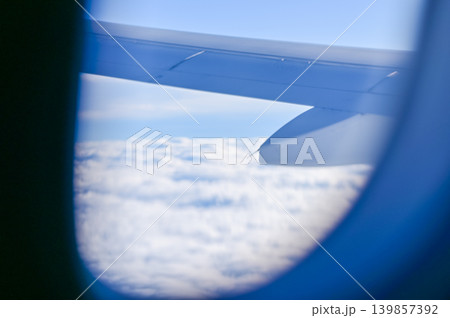 Looking from the airplane window with stunning skyscapes and landscape with airplane wing. Travel and transportation concept. Looking from the airplane window with stunning skyscapes and landscape with airplane wing. Travel and transportation concept. 139857392