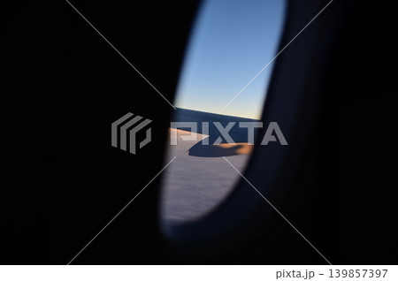 Looking from the airplane window with stunning skyscapes and landscape with airplane wing. Travel and transportation concept. Looking from the airplane window with stunning skyscapes and landscape with airplane wing. Travel and transportation concept. 139857397