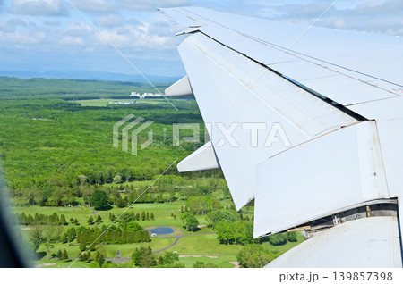 Looking from the airplane window with stunning skyscapes and landscape with airplane wing. Travel and transportation concept. Looking from the airplane window with stunning skyscapes and landscape with airplane wing. Travel and transportation concept. 139857398