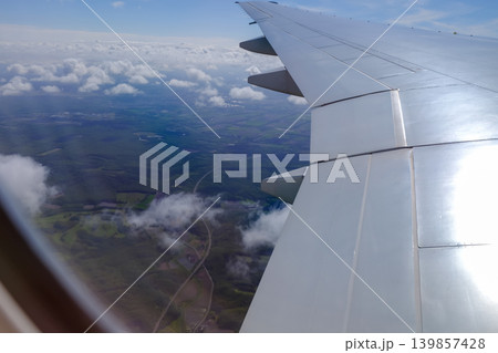 Looking from the airplane window with stunning skyscapes and landscape with airplane wing. Travel and transportation concept. 139857428