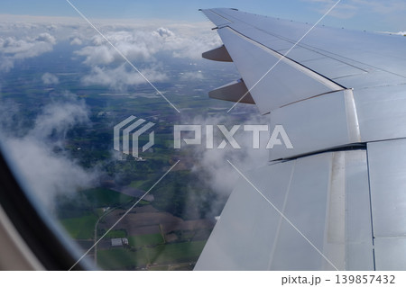 Looking from the airplane window with stunning skyscapes and landscape with airplane wing. Travel and transportation concept. 139857432