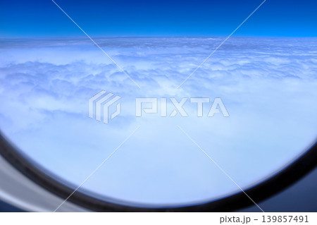 Looking from the airplane window with stunning blue sky and cloudscape. Amazing cloudscape from aerial angle. Travel and nature concept. Looking from the airplane window with stunning blue sky and cloudscape. Amazing cloudscape from aerial angle. Travel and nature concept. 139857491