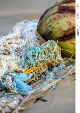 Discarded fishing nets and plastic waste polluting tropical beach. Marine Pollution, ocean debris and environmental damage concept 139858237