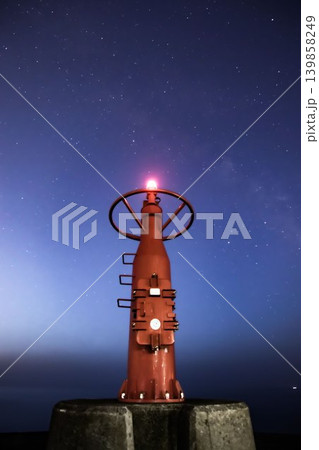 星空の下で光る赤い灯台 139858249