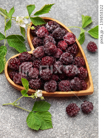 Frozen blackberries in heart shaped wooden bowl 139858322