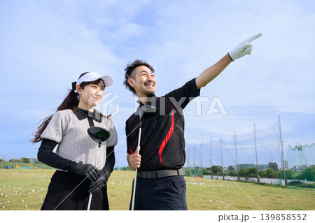 ゴルフ練習場で指差しをする日本人男女 ゴルフ練習場で指差しをする日本人男女 139858552