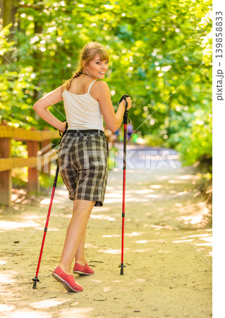 Back view woman hiking in forest pathway Back view woman hiking in forest pathway 139858833