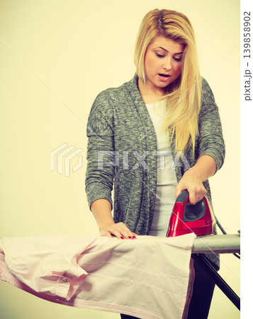 Woman having enough of ironing clothes Woman having enough of ironing clothes 139858902