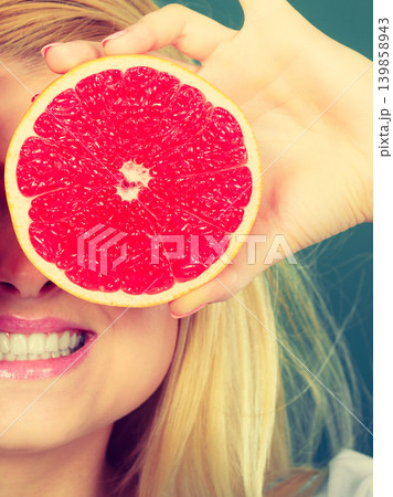 Woman holding fruit red grapefruit half 139858943